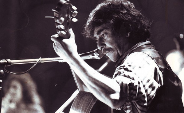Ángel Parra en foto blanco y negro toca la guitarra