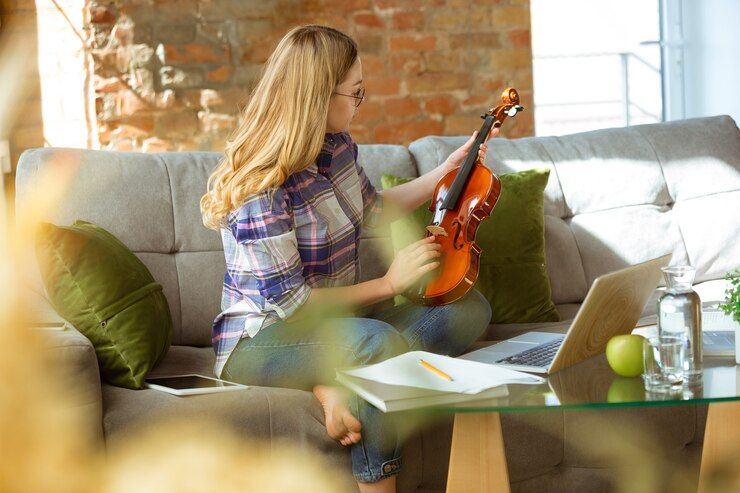Mujer con un violín en la mano, lo mira para aprender un nuevo instrumento