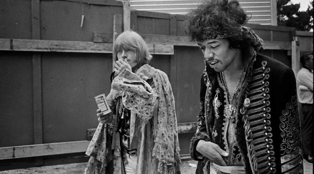 Brian Jones y Jimi Hendrix, miembros del club de los 27, caminando entre bastidores de algún festival de música