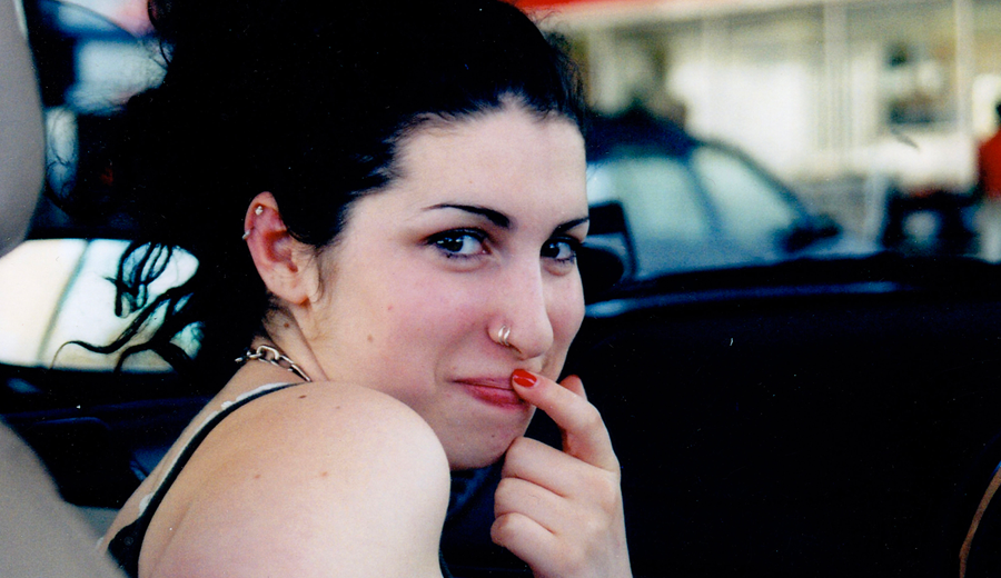 Amy Winehouse joven, con el dedo de la mano izquierda en la boca