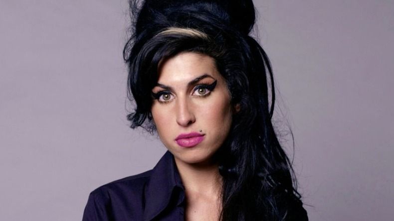 Amy Winehouse posa para la foto con su maquillaje y cabello clásicos
