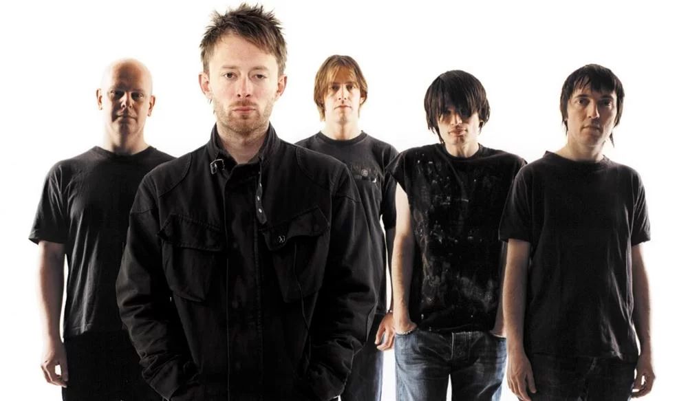 Los integrantes de Radiohead en un fondo blanco mirando a la cámara 