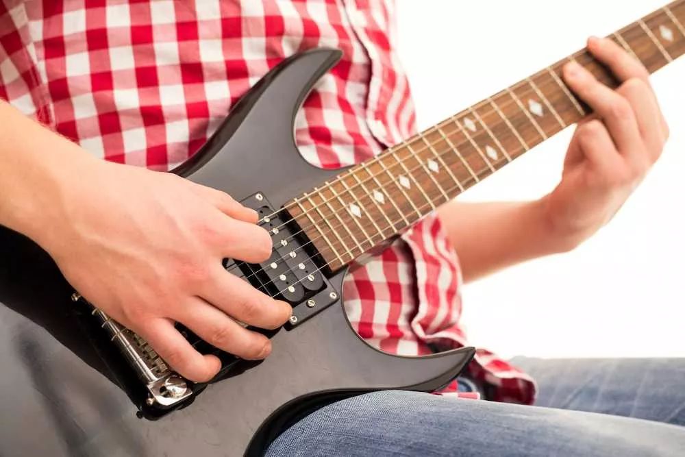 Manos de un hombre tocando una guitarra eléctrica rápido