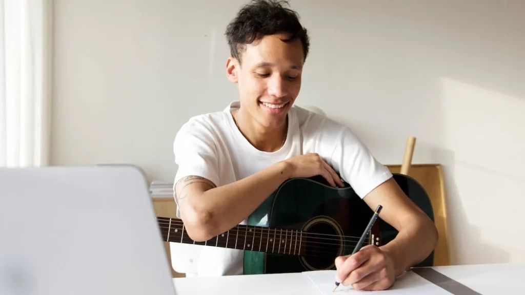 Hombre estudiando música con la computadora abierta