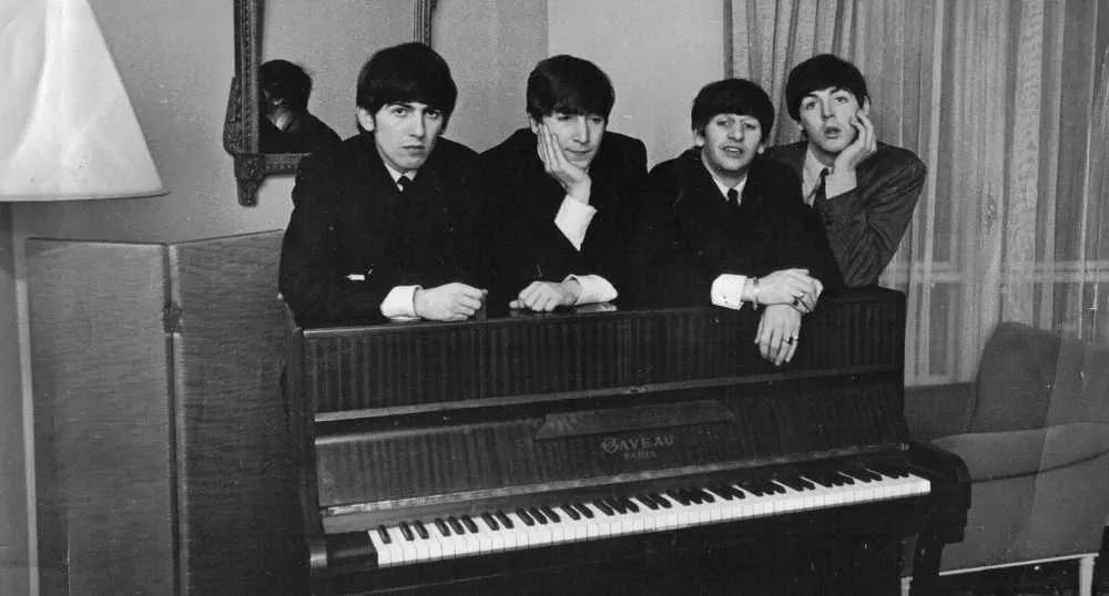 Los Beatles posan para foto en un piano
