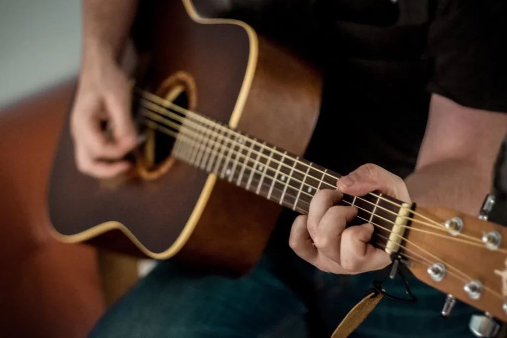 Hombre tocando la guitarra formando acordes