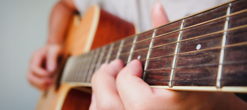 Manos tocando una guitarra acústica