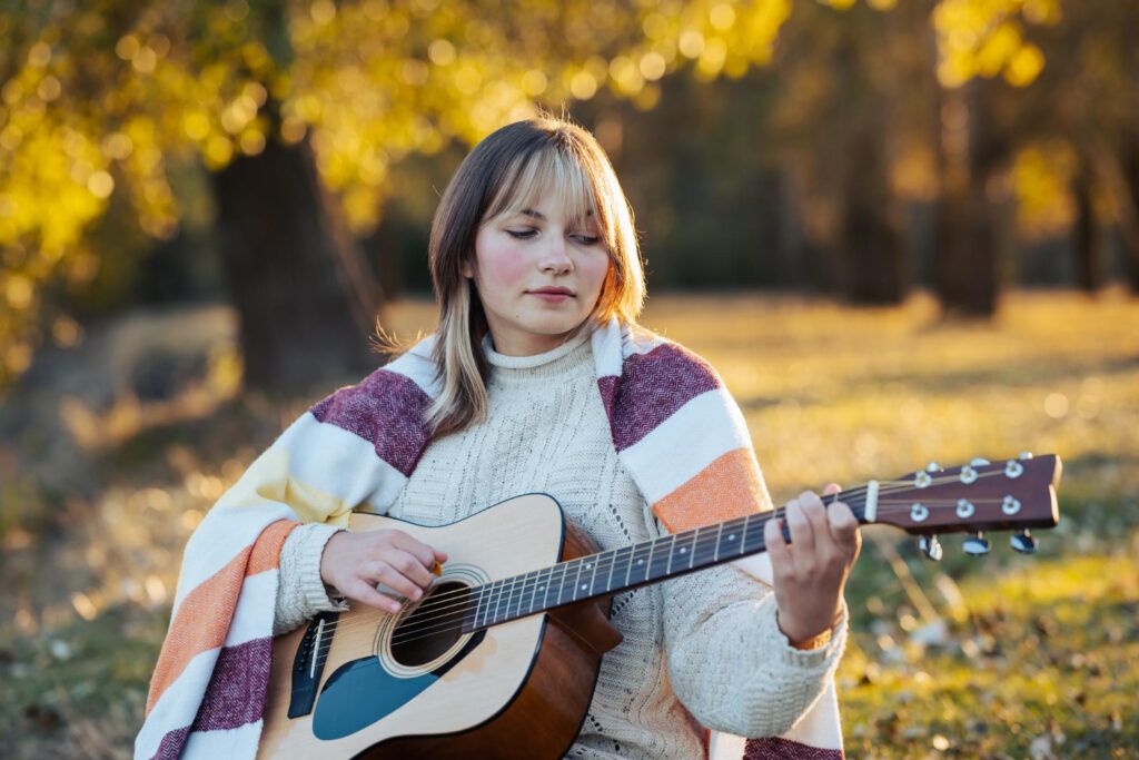 Chica toca la guitarra en temperatura fría
