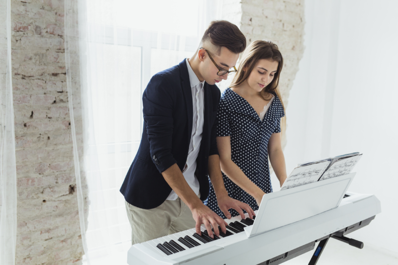 Pareja joven tocando el teclado juntos