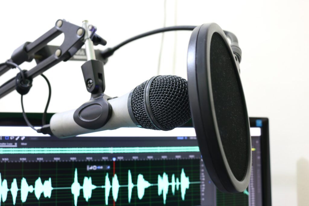 Microfone e programa de computador prontos para a gravação de um podcast