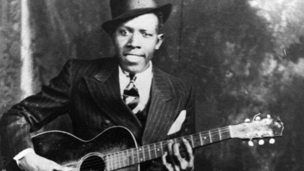 Robert Johnson, um dos principais artistas de blues antigos, tocando violão