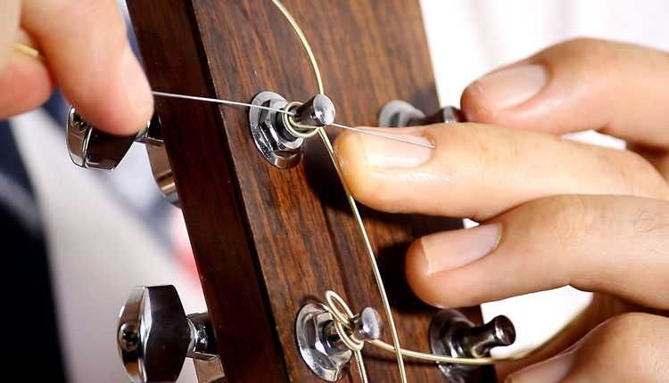 Violonista trocando as cordas do seu instrumento