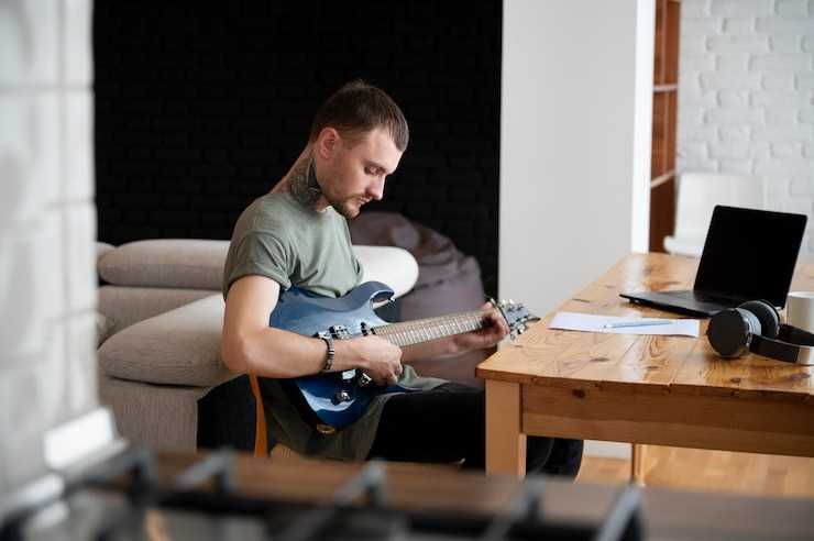 Guitarrista estudia en casa