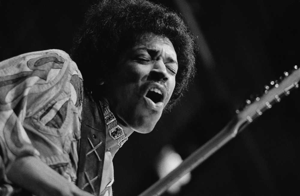 Jimi Hendrix tocando guitarra em show