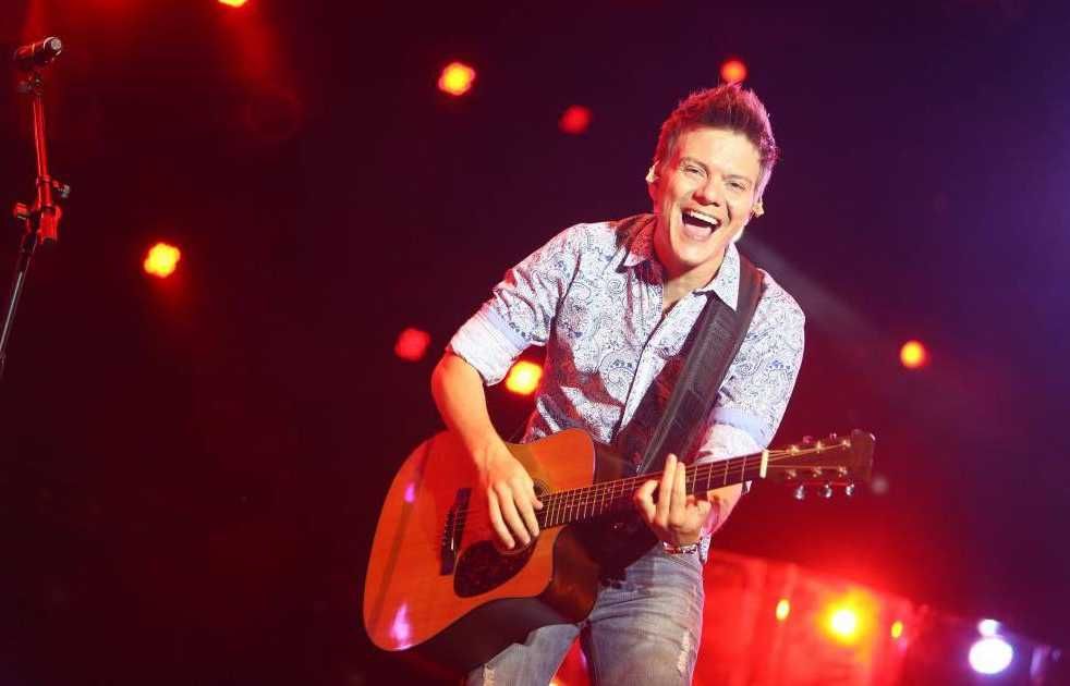 Michel Teló tocando violão em show