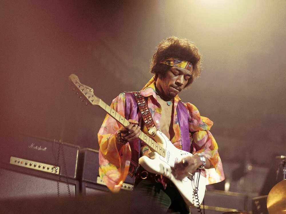 Jimi Hendrix tocando guitarra de olhos fechados em show