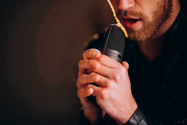 Vocalista cantando segurando microfone condensador