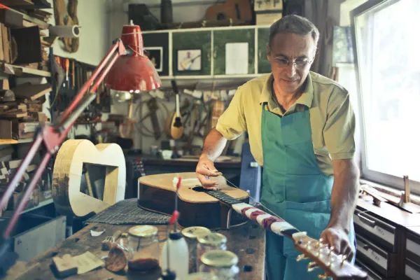 Luthier consertando um violão