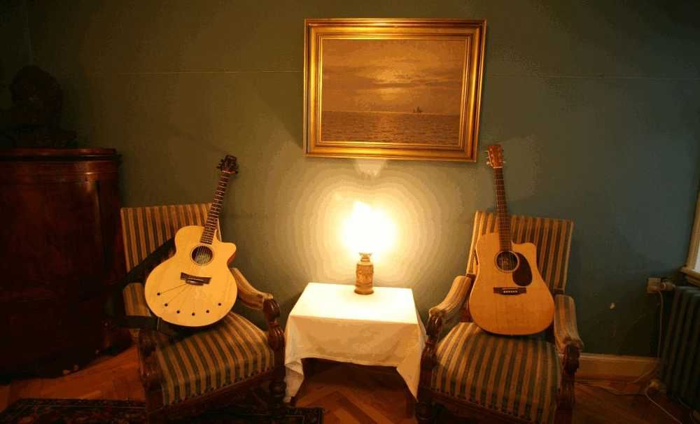 Sala de estar de uma casa com dois violões em cadeiras