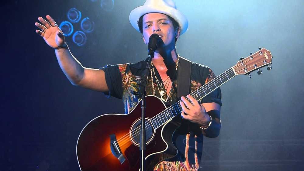 Bruno Mars cantando e tocando violão em show