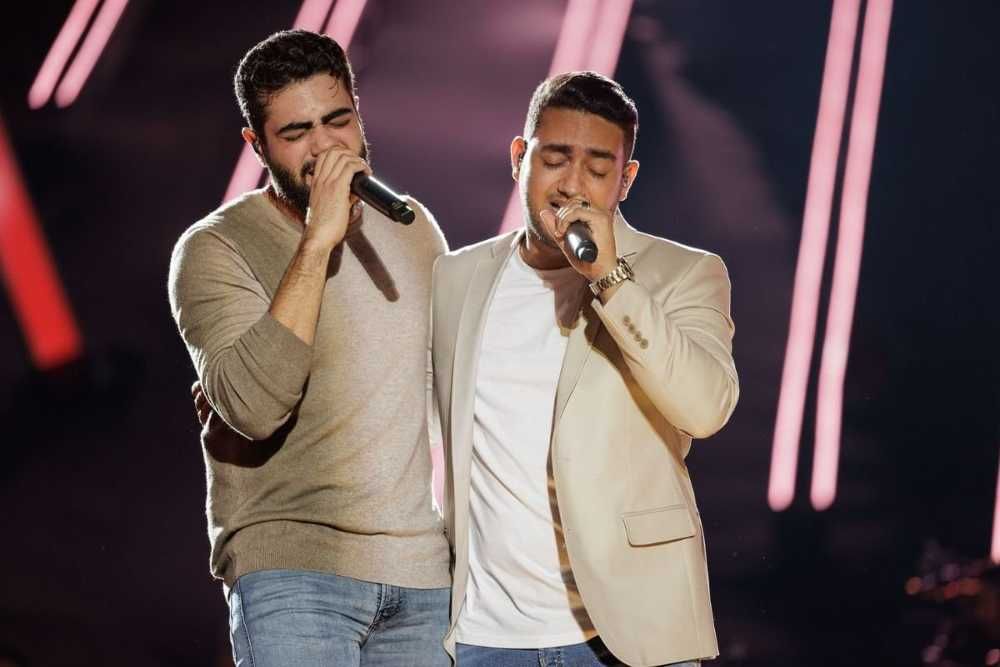 Henrique e Juliano cantando abraços em show