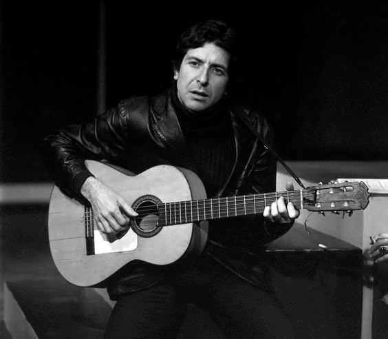Leonard Cohen tocando violão sentado