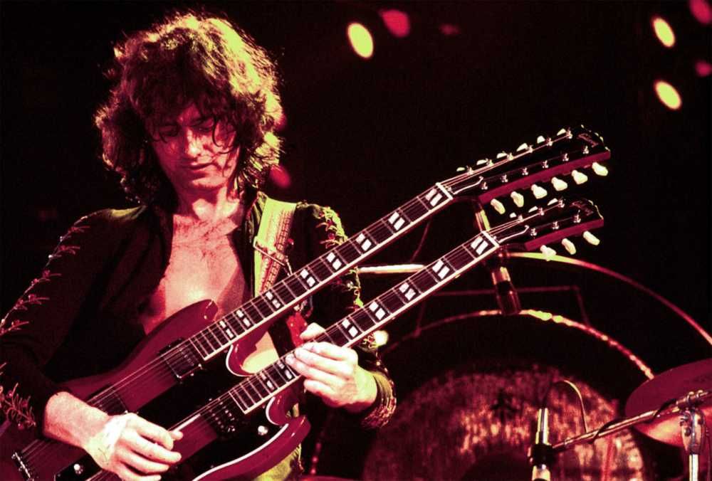 Jimmy Page fazendo um solo na sua guitarra de dois braços em show do Led Zeppelin