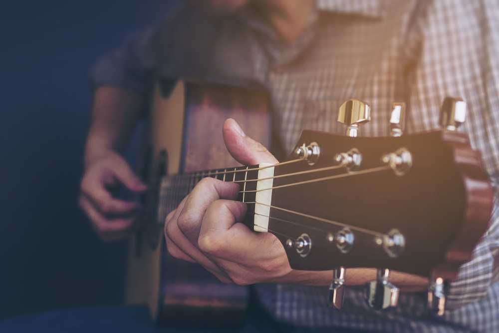 Homem tocando violão com acordes sem pestana