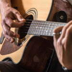uma pessoa tocando violão - melhores cifras de MPB