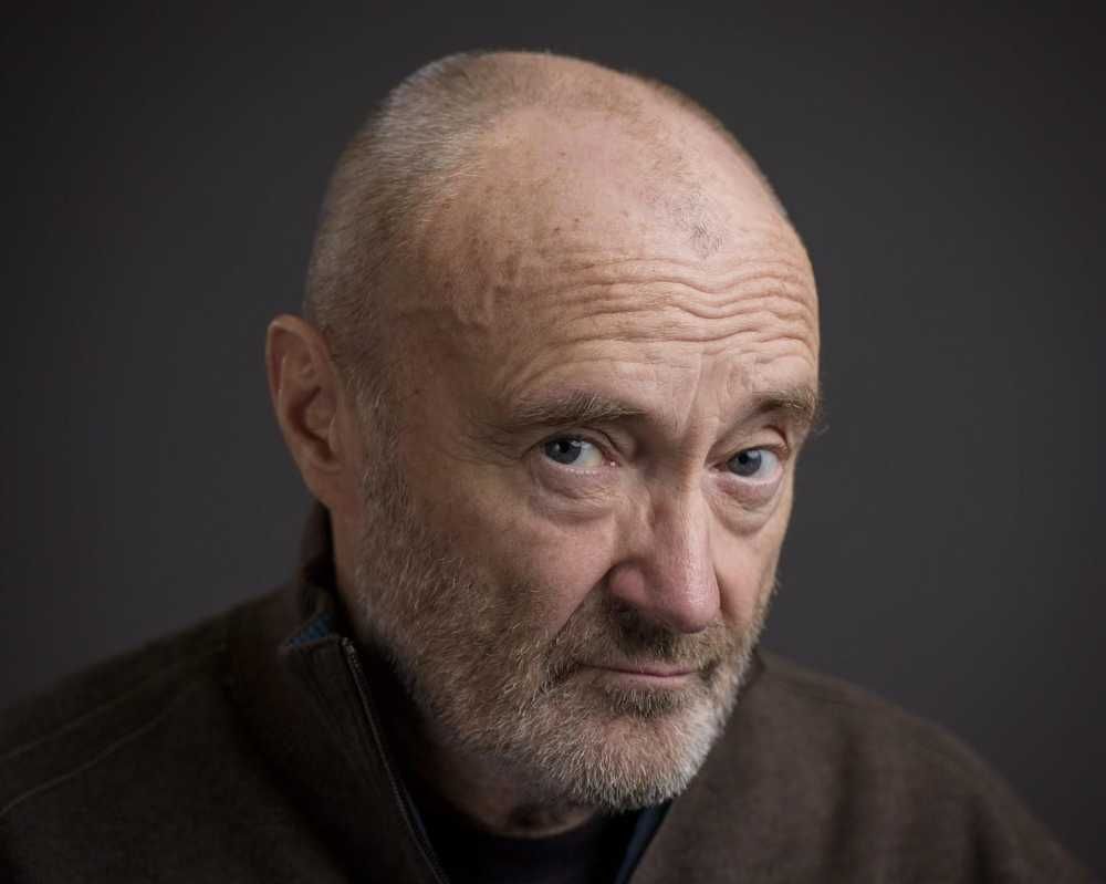 Registro de perto de Phil Collins olhando para a câmera com cara séria