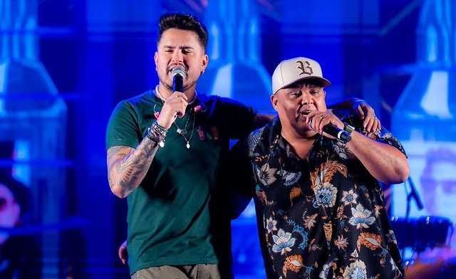 Humberto e Ronaldo cantando abraçados em show