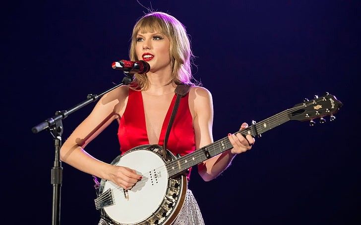 Taylor Swift tocando banjo e cantando em show