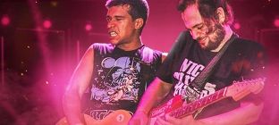 Dois integrantes da banda Darvin lado a lado tocam guitarra no centro da imagem