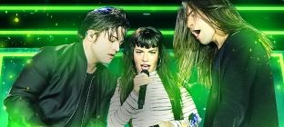 Vocalista da The Band Perry canta e os outros integrantes da banda tocam violão e baixo lado a lado no centro da imagem