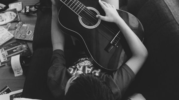 joven tocando la guitarra acústica