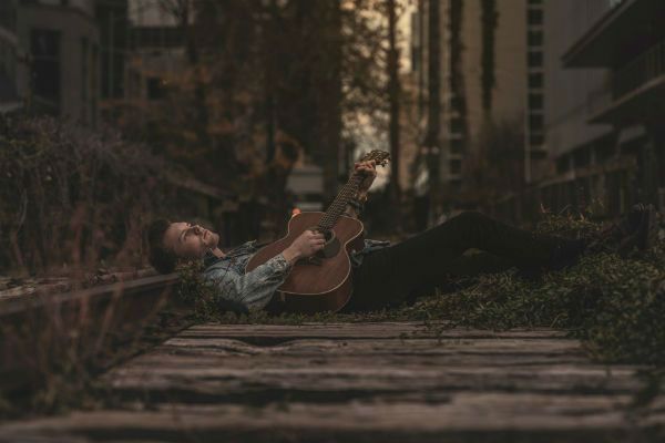 joven relajado tocando la guitarra