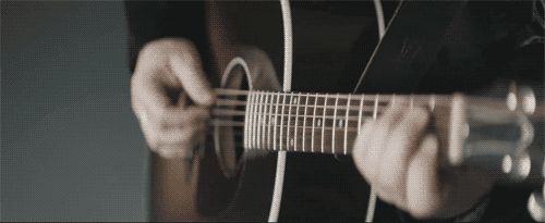 Persona tocando la guitarra acústica