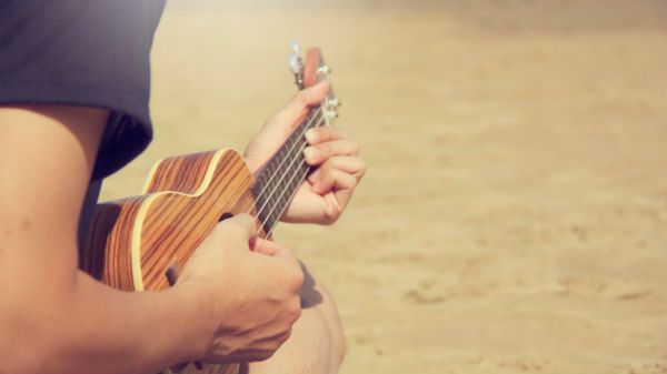 Músico toca ukulele na praia