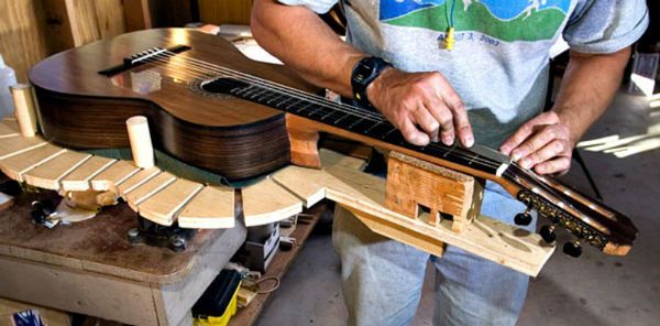 Luthier trabalha no braço de um violão