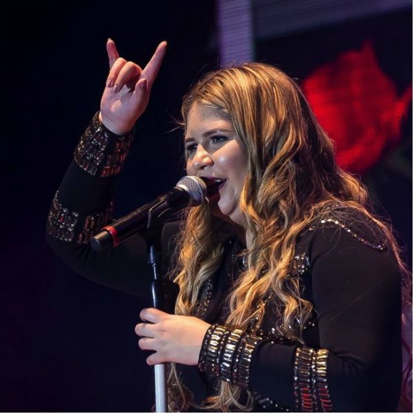 Cantora Marília Mendonça faz sinal de chifre com os dedos