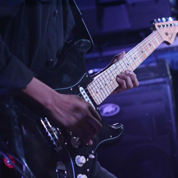 Guitarrista haciendo un solo de guitarra en un concierto
