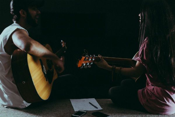 Dos personas tocando guitarra juntas