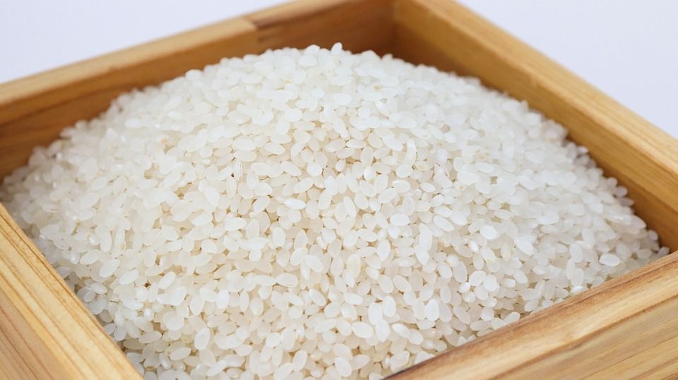 arroz cru em um recipiente de madeira