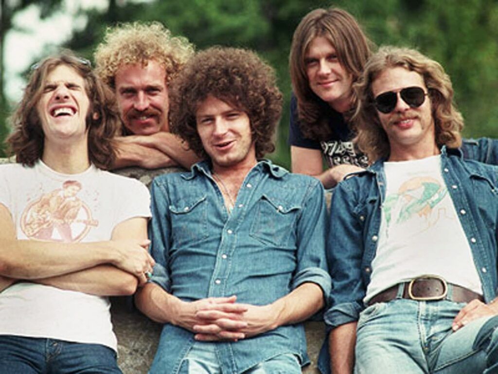 En la imagen, están los 5 miembros de Eagles mirando hacia la cámara y sonriendo