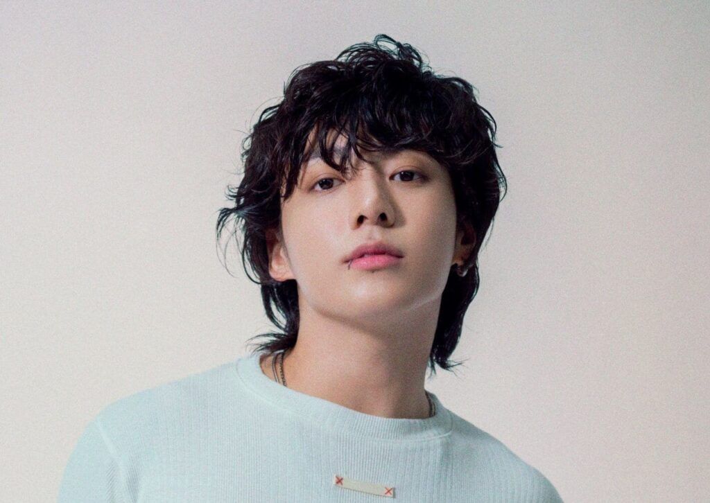 En la imagen, está Jungkook mirando hacia la cámara