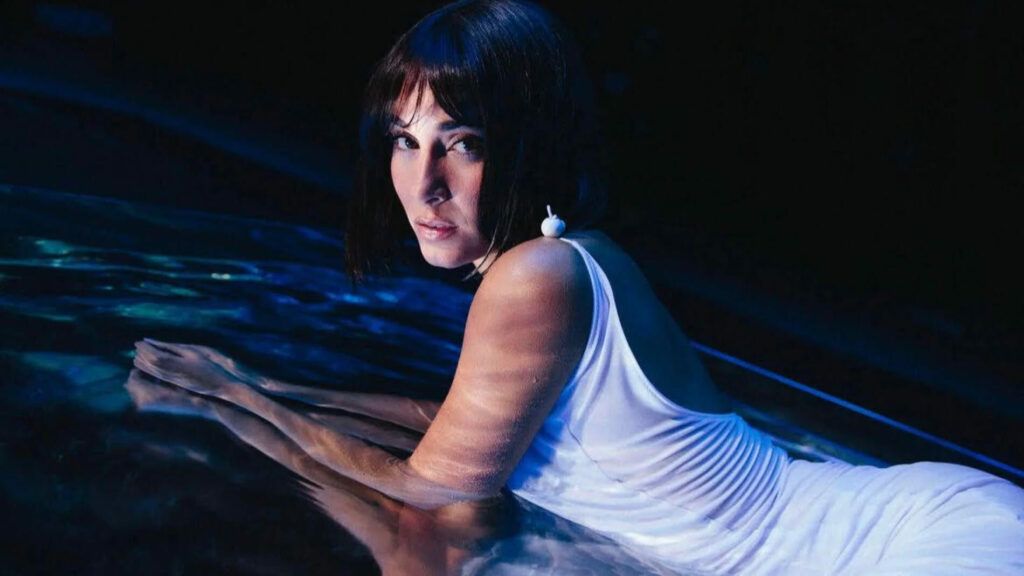 En la imagen, está Aitana tirada al piso y mirando hacia la cámara