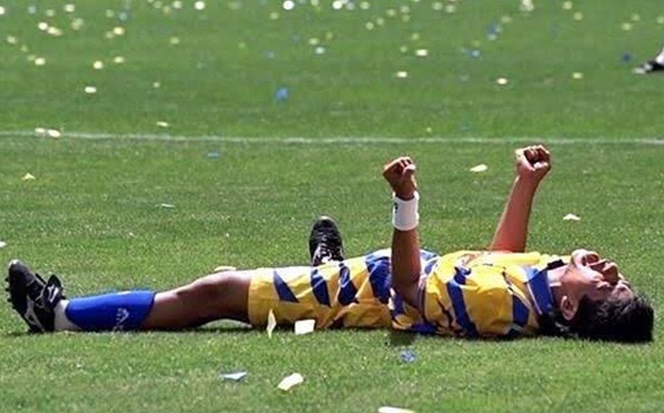 Jugador de fútbol tumbado en la cancha tras una derrota.