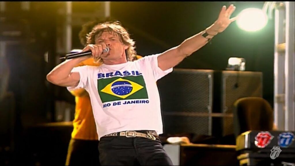 Mick Jagger cantando com camisa do Brasil
