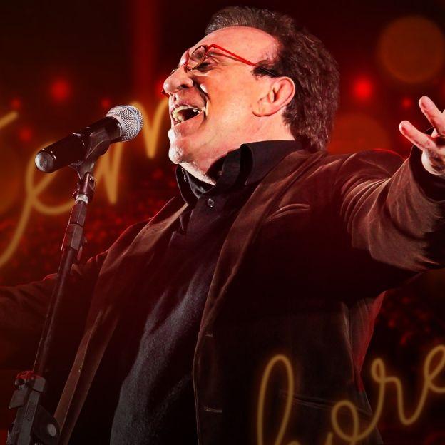 O cantor Moacyr Franco canta com os braços abertos no canto direito da imagem