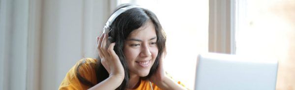Garota com traços orientais ouve música no fone de ouvido